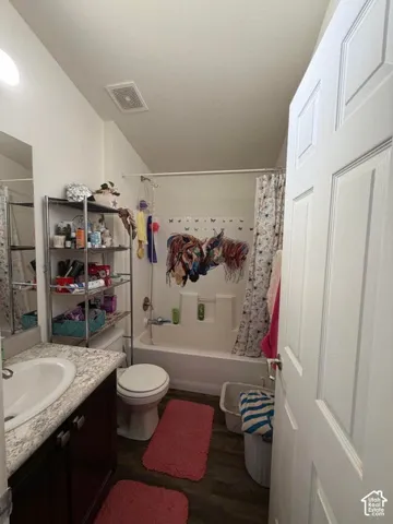 White paneled door opening into a bathroom featuring a dark wood-finish vanity with a white countertop and integrated sink