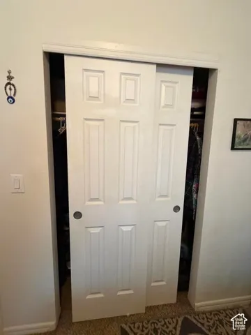 White six-panel sliding closet doors with dark hardware