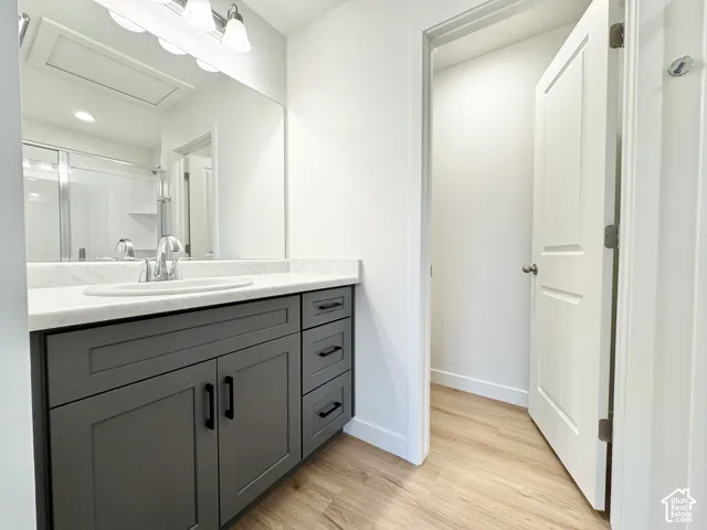 Bathroom vanity with a white countertop and integrated sink, dark gray cabinetry, and brushed nickel faucet