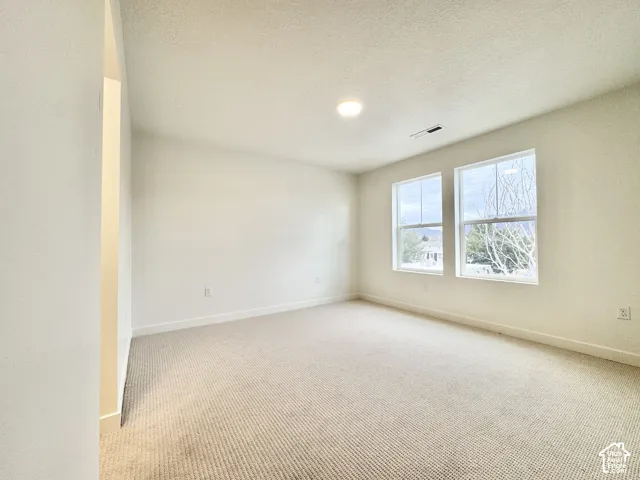 Carpeted room featuring two large windows, recessed lighting, and crisp white walls