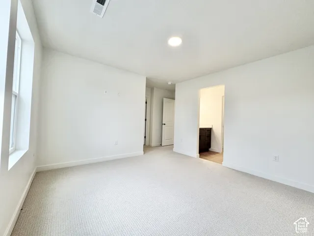 Neutral tone wall paint, recessed lighting, white trim, and light-colored carpeting