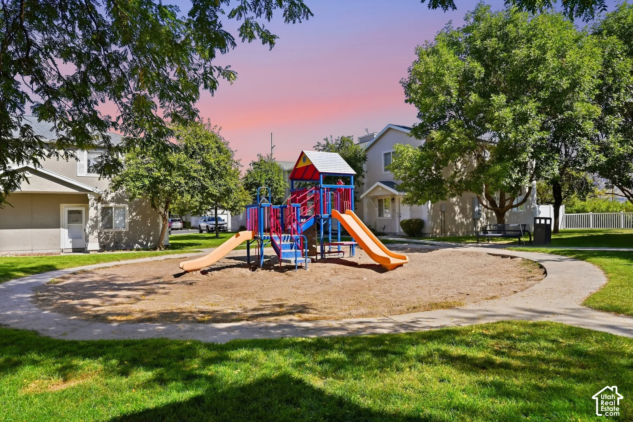 Central playground area featuring a colorful play structure with slides, surrounded by a gravel surface