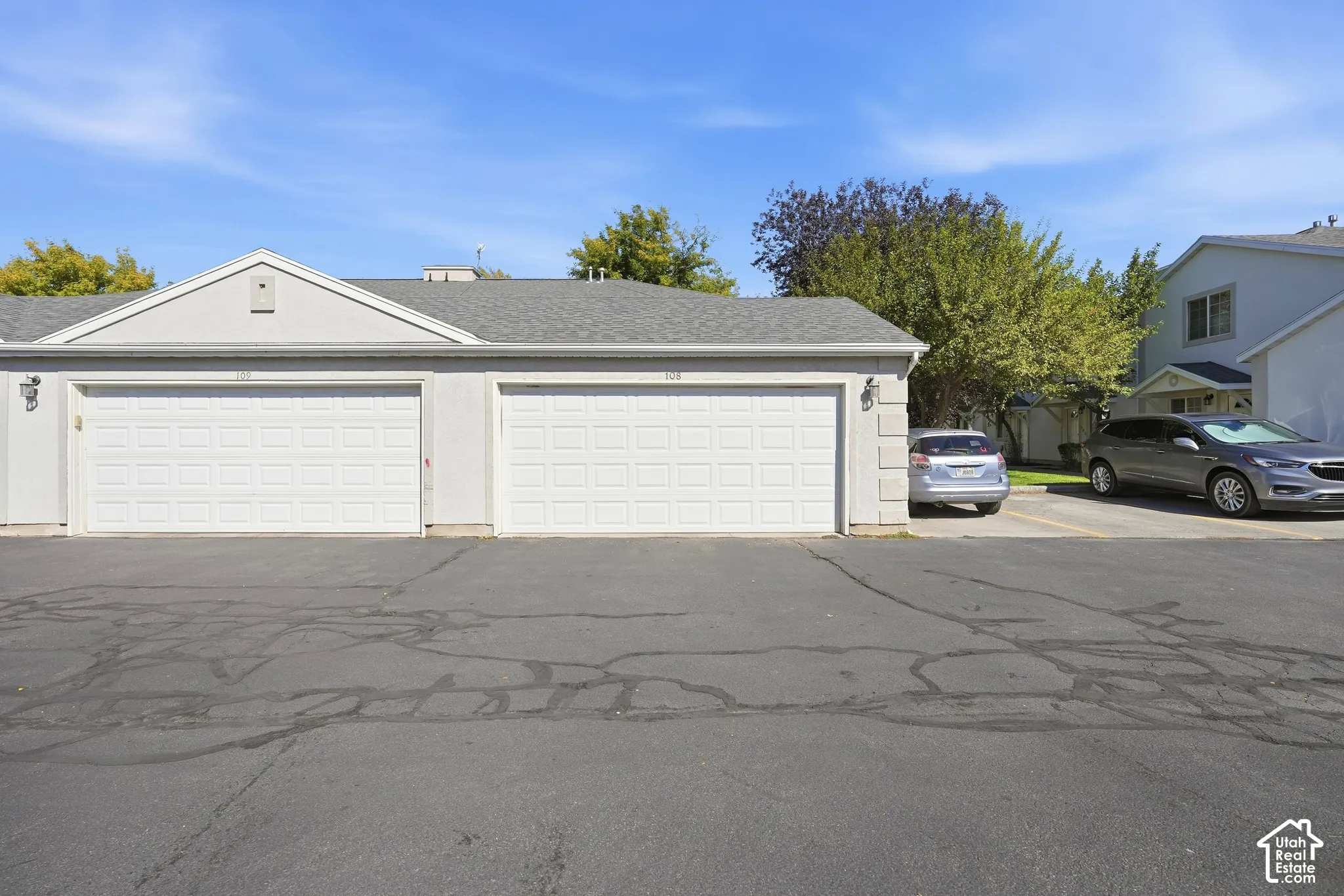Two-car garage with white paneled doors and stucco exterior