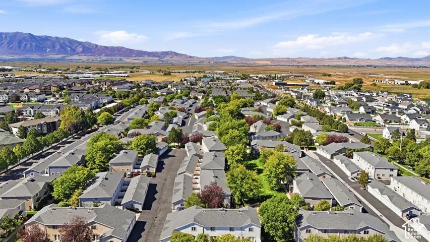 Residential community with multiple buildings, mature landscaping, and mountain scenery