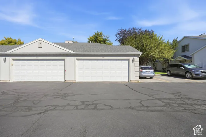 Two-car garage with white paneled doors and stucco exterior