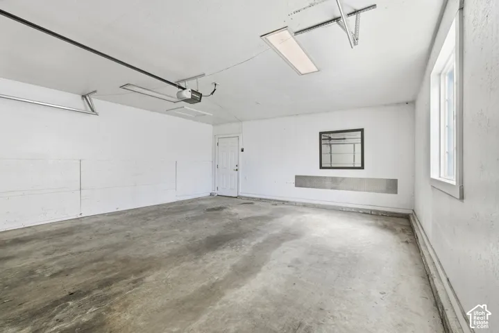 Spacious garage featuring a concrete floor, white walls, and an overhead lighting fixture