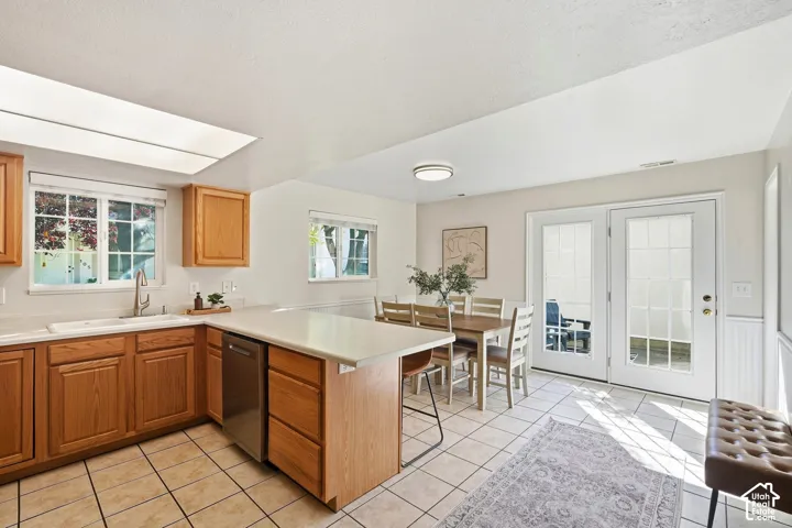 Kitchen with wood cabinetry, light-toned countertops, and tile flooring