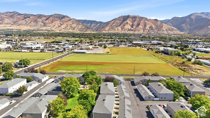 Aerial perspective featuring multi-unit properties and extensive green spaces with a mountain backdrop