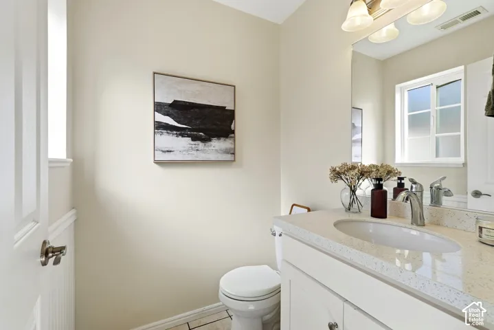 Vanity with an integrated oval sink, stone-finish countertop, and chrome faucet
