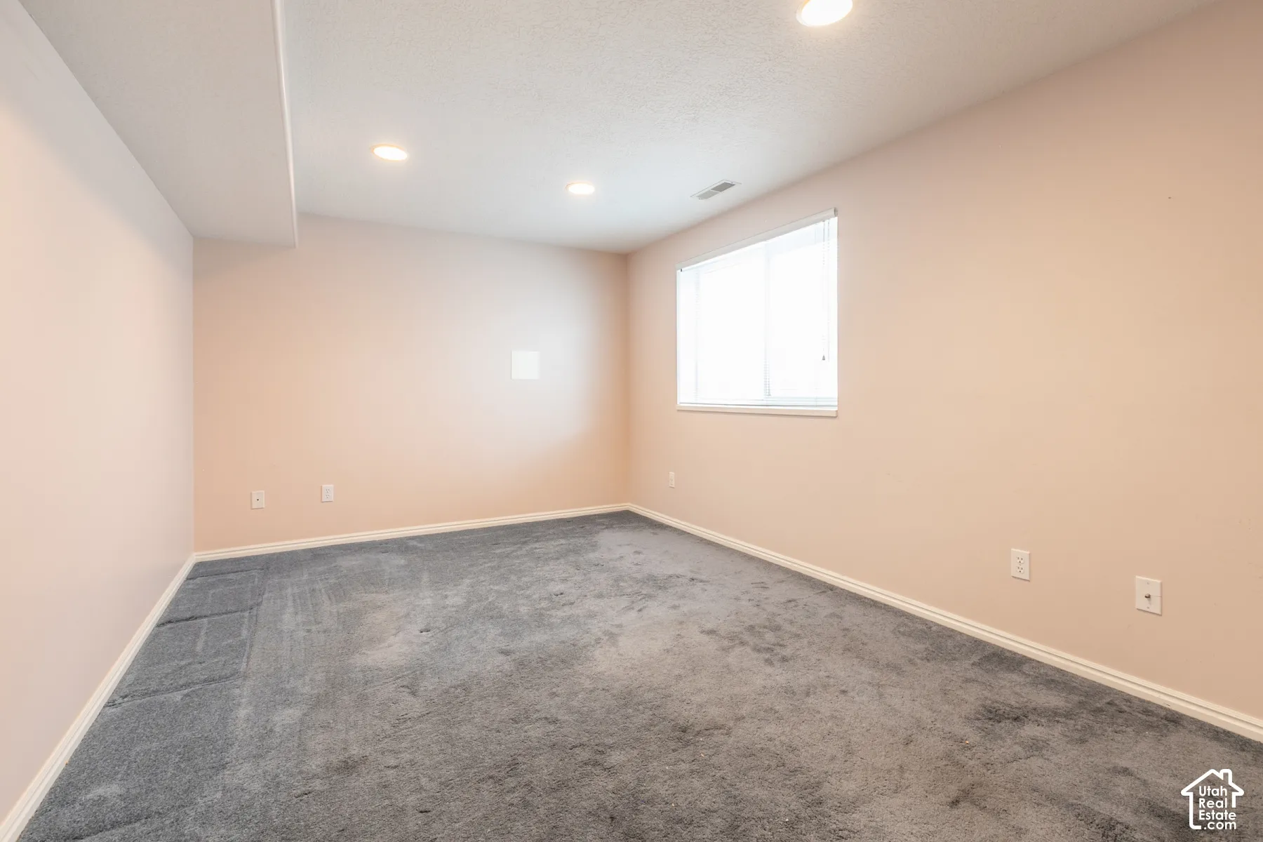 Interior room featuring neutral wall paint, carpeting, recessed lighting, and a single-pane window