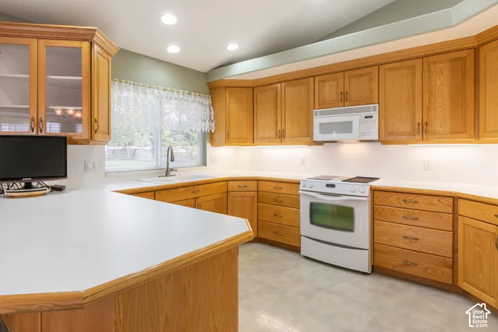 Kitchen featuring solid wood cabinetry, white countertops, recessed lighting, white built-in appliances, and a window above the sink