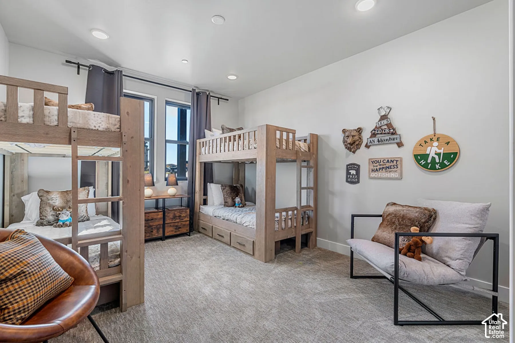 Recessed lighting, light-toned carpeting, and multiple windows with dark framing
