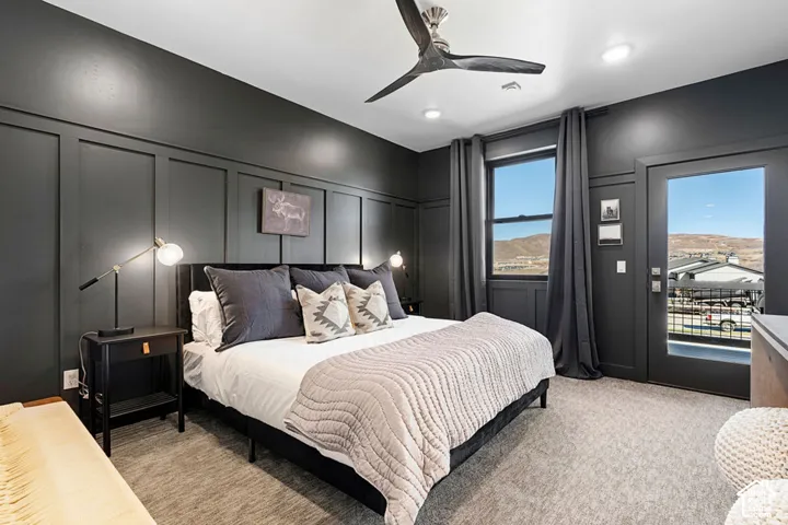 Accent wall with paneling, ceiling fan with integrated lighting, recessed lighting, carpet flooring, and a glass-paneled door