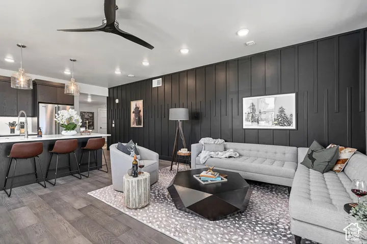 Open-concept living space featuring wood-finish flooring, a contemporary ceiling fan, and recessed lighting