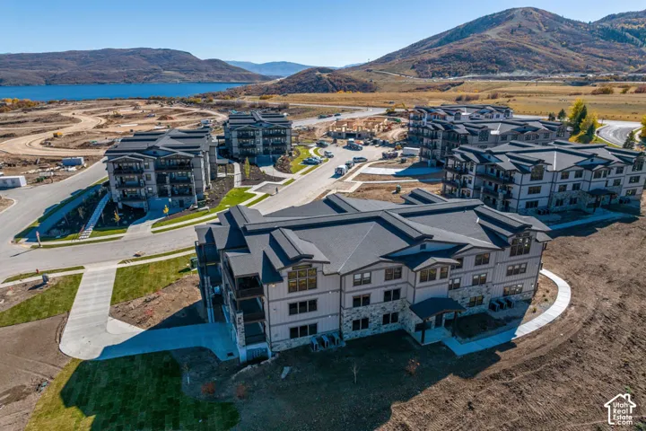 Newly constructed multi-story buildings featuring stone and siding exteriors, private balconies, and dark-pitched roofs