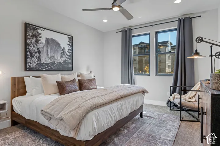 Recessed lighting, ceiling fan, two large windows, dark gray window treatments, and light gray wall paint