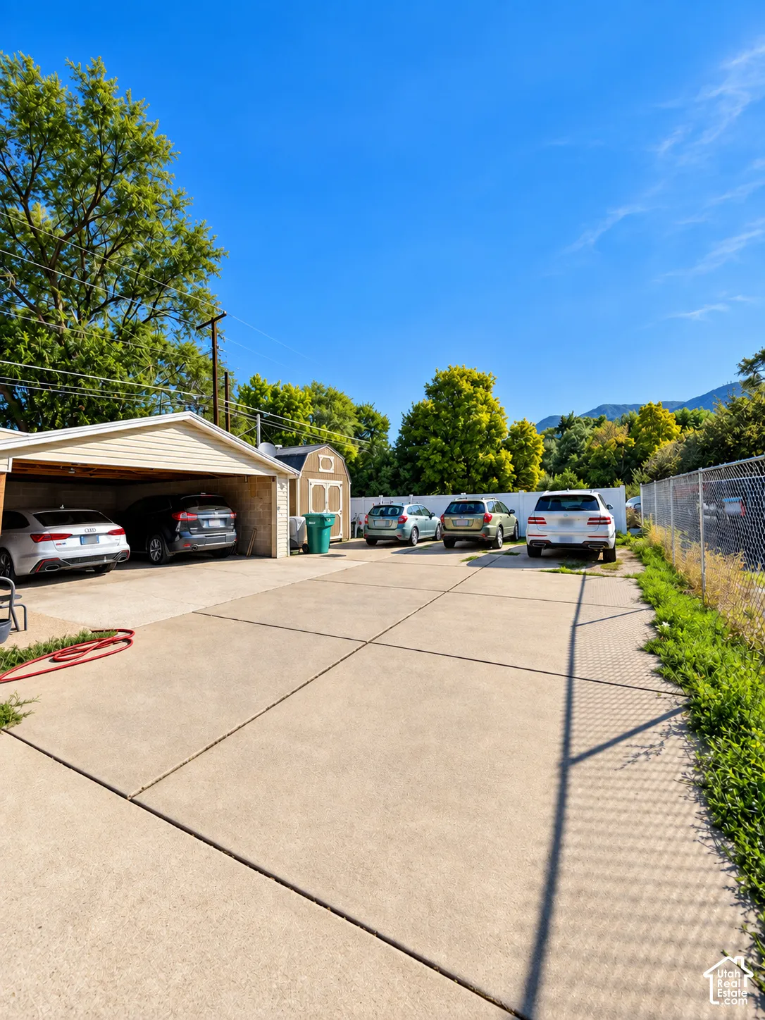 Expansive concrete driveway, detached garage, and a separate storage shed