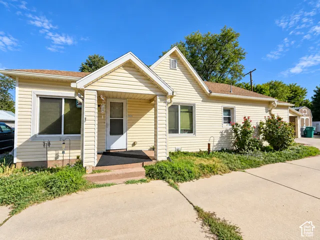 Light-colored siding exterior with a covered front porch and concrete walkway
