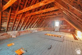 Exposed wood beam ceiling, wood plank flooring, and natural light