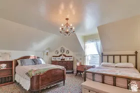 Sloped ceilings, chandelier lighting, and a prominent window