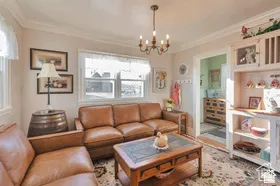 Recessed windows with natural light, crown molding, and a chandelier fixture
