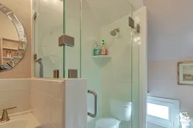 Shower enclosure with clear glass paneling and a corner shelf
