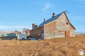 Barn structure featuring a metal roof, weathered wood siding, and an attached silo