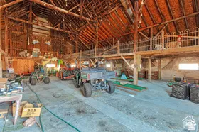 Exposed timber beam construction, concrete flooring, and a second-story loft with decorative iron railing
