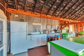Exposed wood beam ceiling, corrugated metal wall paneling, white cabinetry, and a built-in countertop