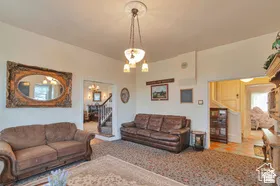 Spacious interior featuring a decorative ceiling medallion, an ornate chandelier, carpeted flooring, and white painted walls