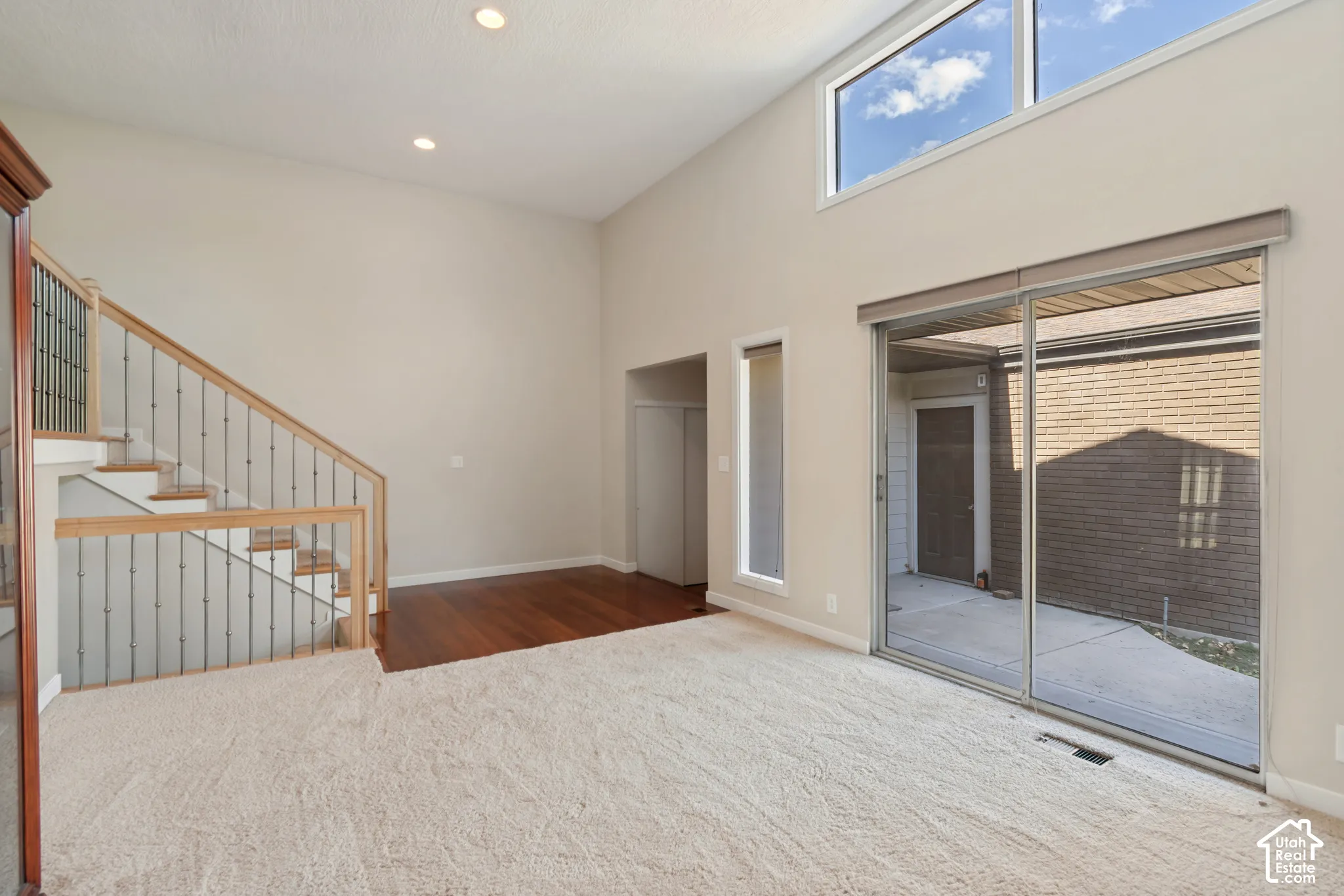 Vaulted ceilings with recessed lighting, wood-finish flooring, sliding glass door, and clerestory window