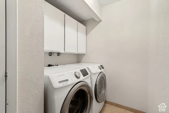Built-in overhead white cabinetry, and light-toned floor tiling