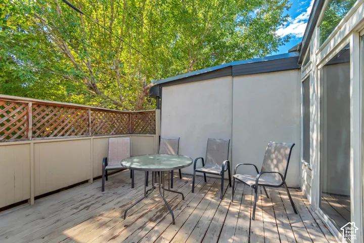 Outdoor deck featuring wood slat flooring and a wood lattice privacy fence