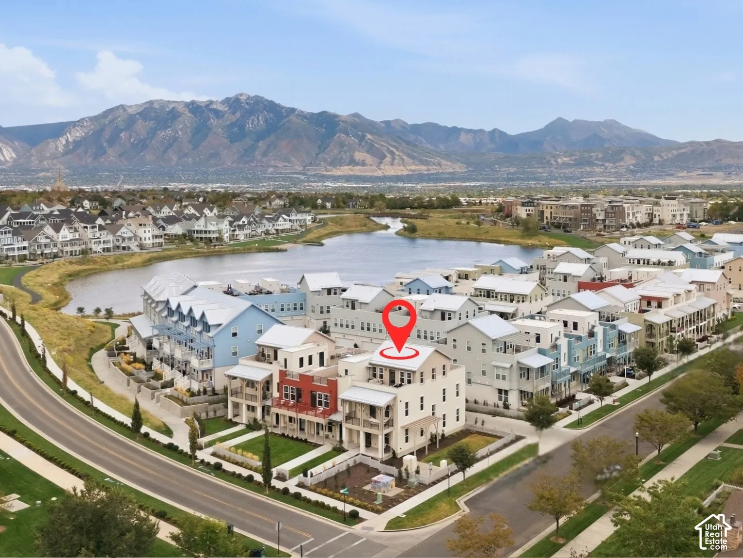 Townhome architecture within a developed community featuring a prominent lake and mountainous landscape