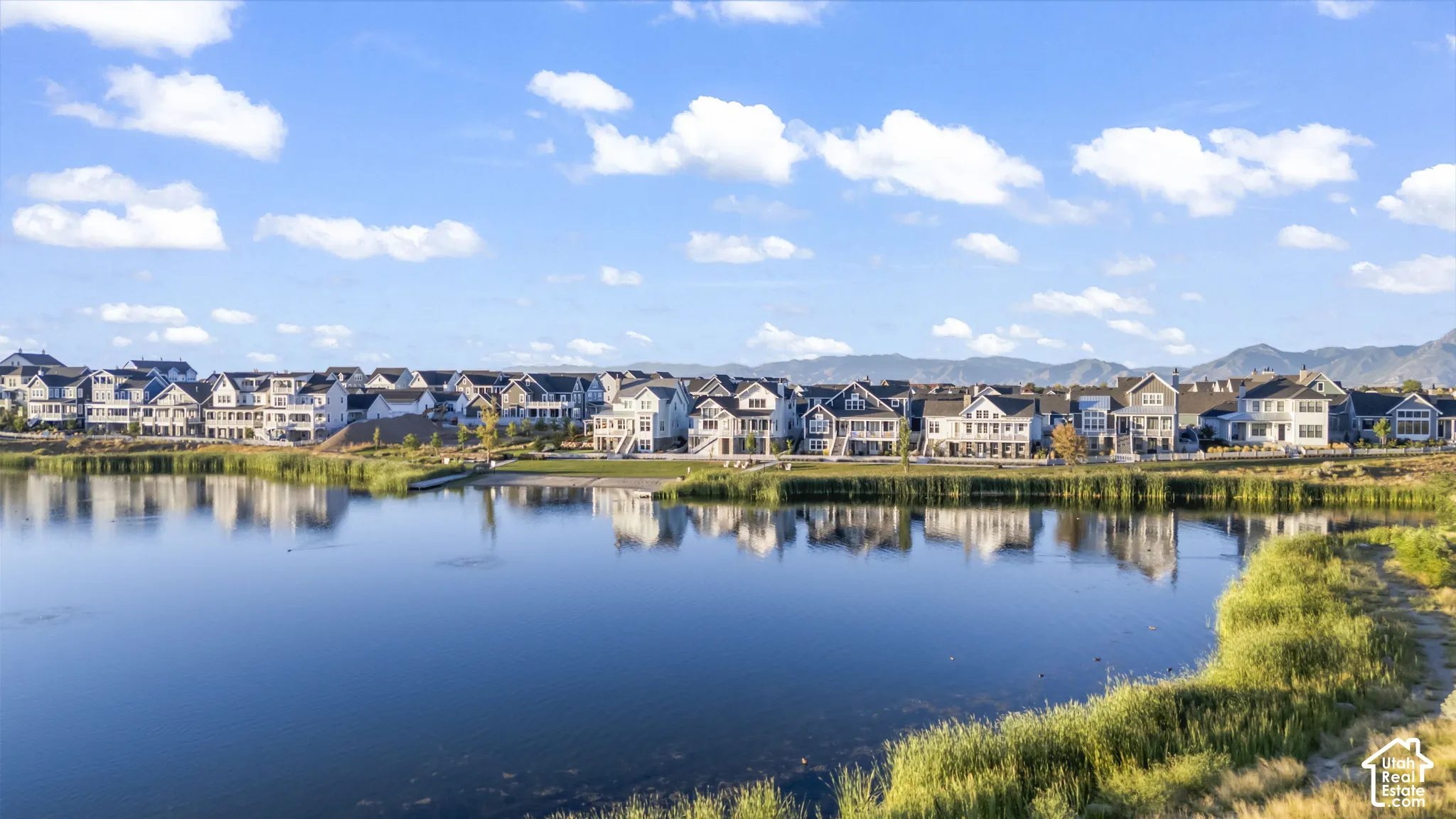 Waterfront properties with mountain backdrop, offering multiple balconies and varied architectural styles