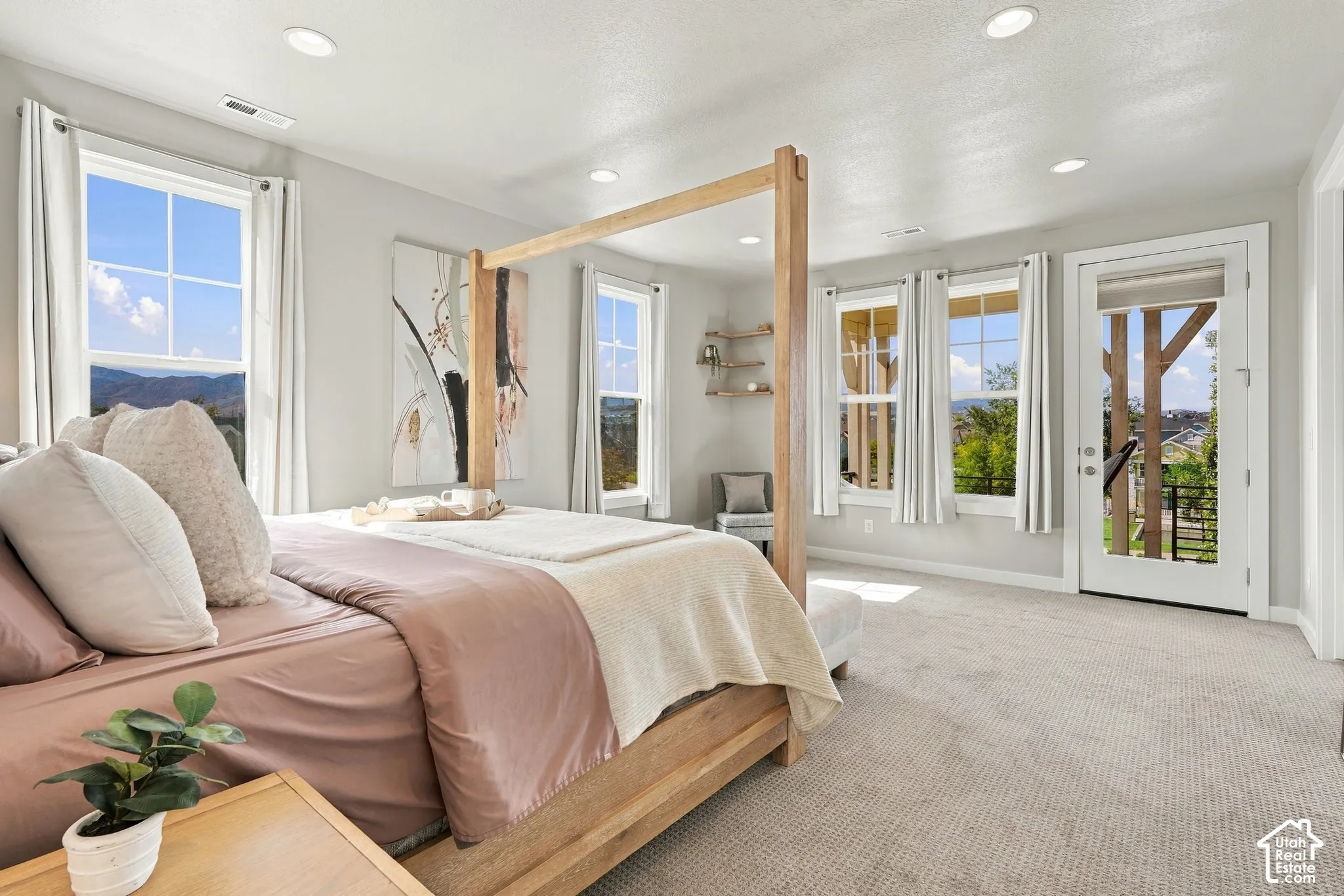 Recessed lighting, light-toned walls, and abundant natural light from multiple windows and a glass-paneled door