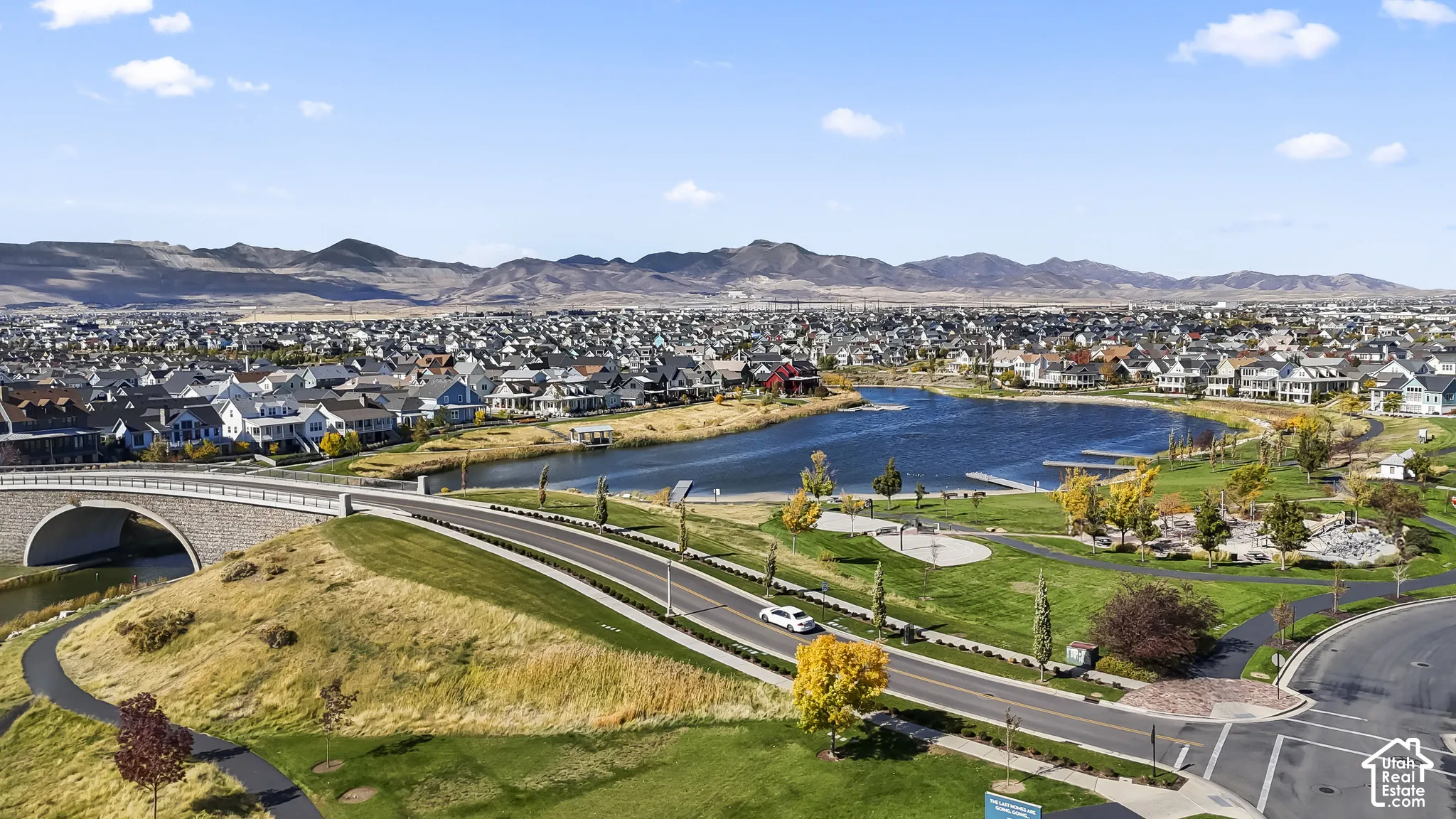 Expansive community featuring a large pond, recreational green spaces, and a walking path