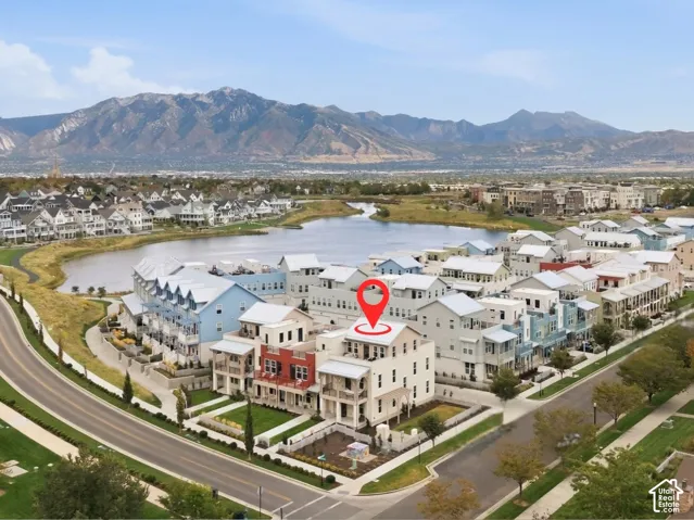 Townhome architecture within a developed community featuring a prominent lake and mountainous landscape