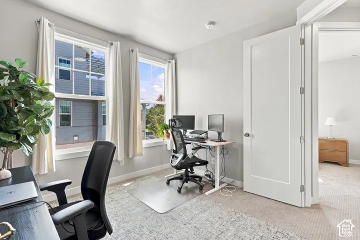 Carpeted room featuring dual windows, recessed ceiling lighting, and a solid interior door