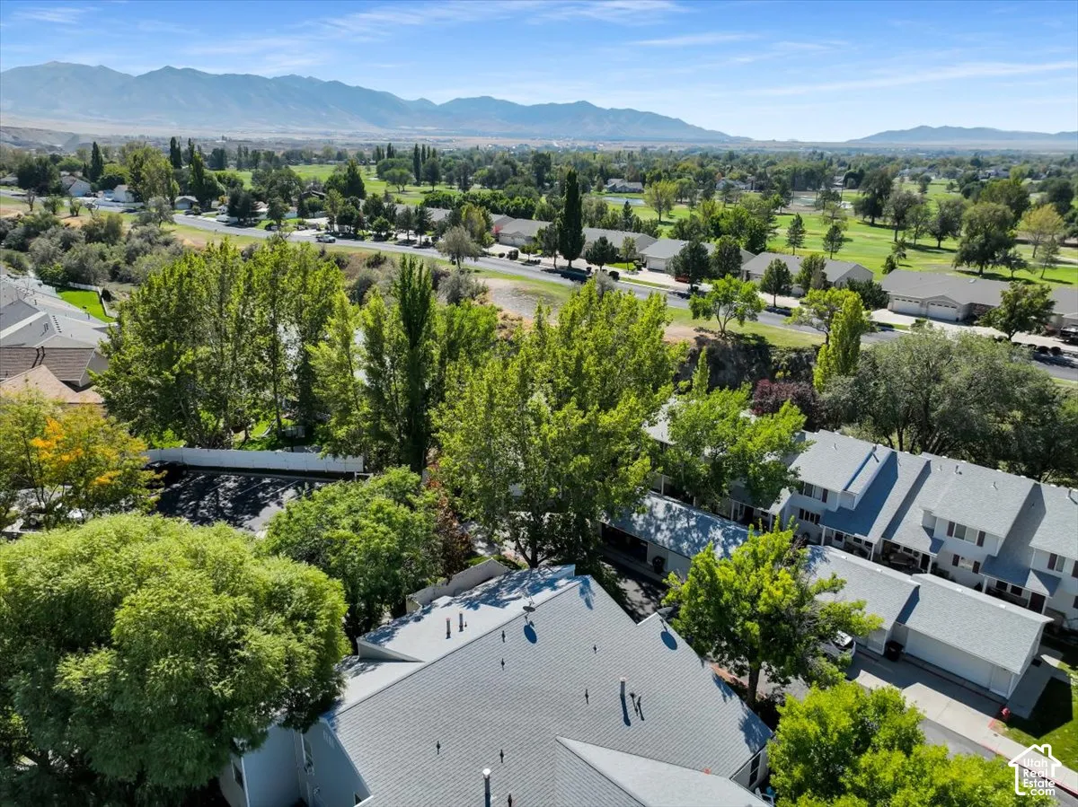 Residential property with pitched roofs and surrounding mature trees, offering mountain scenery and golf course access