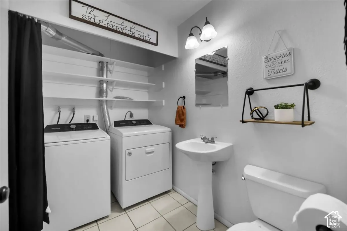 Pedestal sink, wall-mounted mirror, two-light vanity fixture, built-in shelving, tile flooring