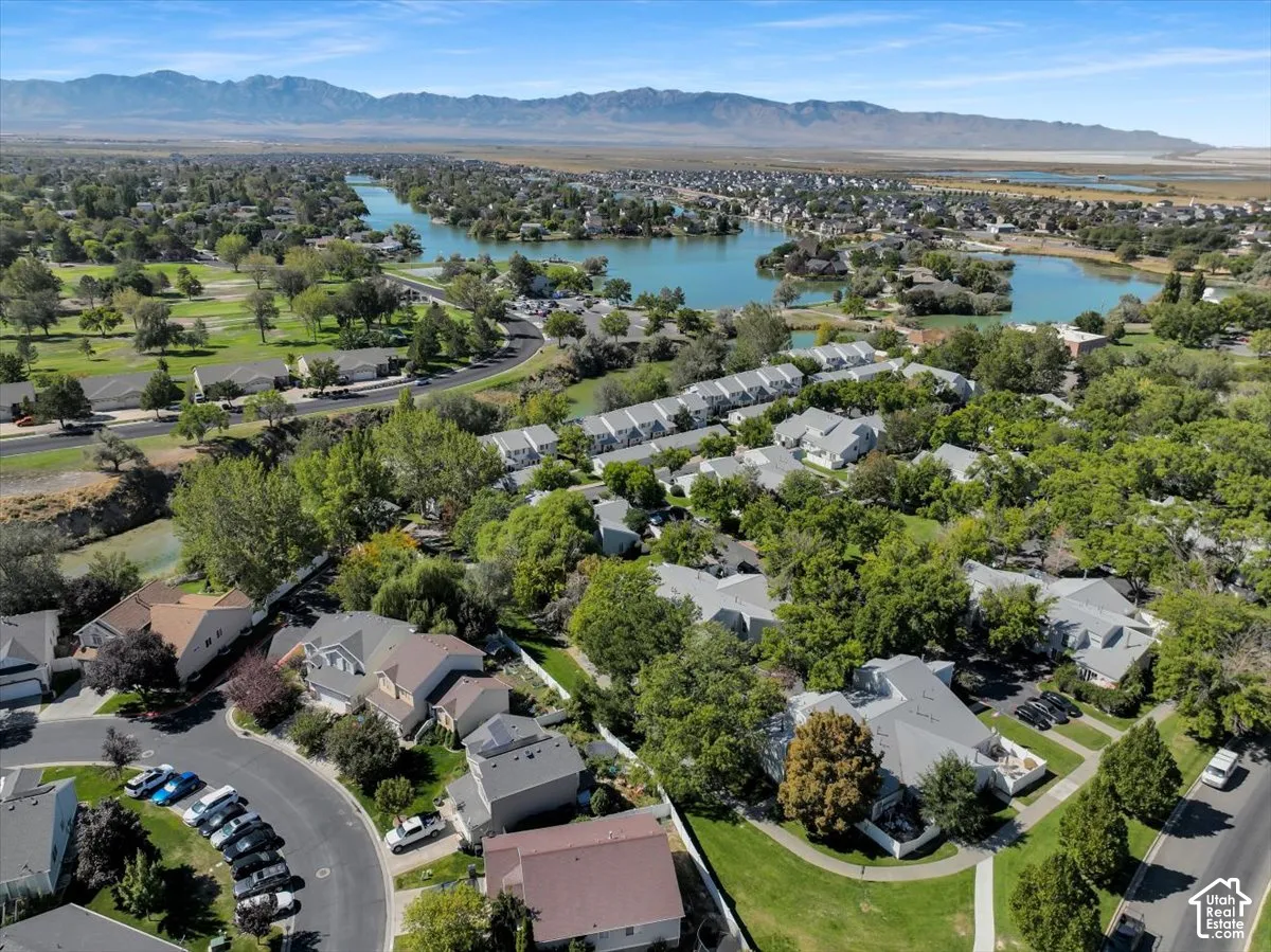 Residential area with lake, tree-lined streets, and distant mountains