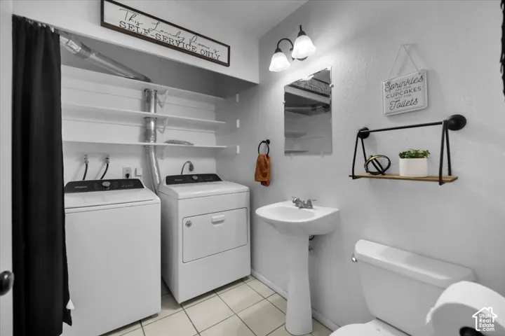Pedestal sink, wall-mounted mirror, two-light vanity fixture, built-in shelving, tile flooring