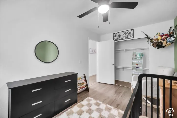 Light-toned wood-finish flooring, white walls, and a ceiling fan with integrated lighting
