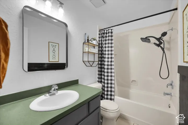 Bathroom featuring a single vanity with a green countertop, undermount sink, and a framed mirror