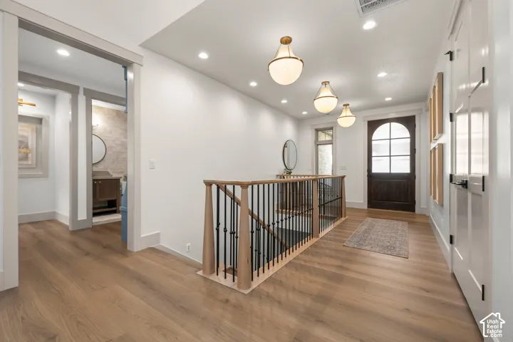 Light wood-finish flooring with a dark wood arched door
