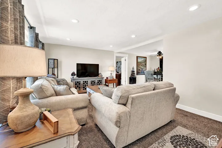Recessed ceiling lighting, neutral wall finishes, carpeted flooring, and a media cabinet