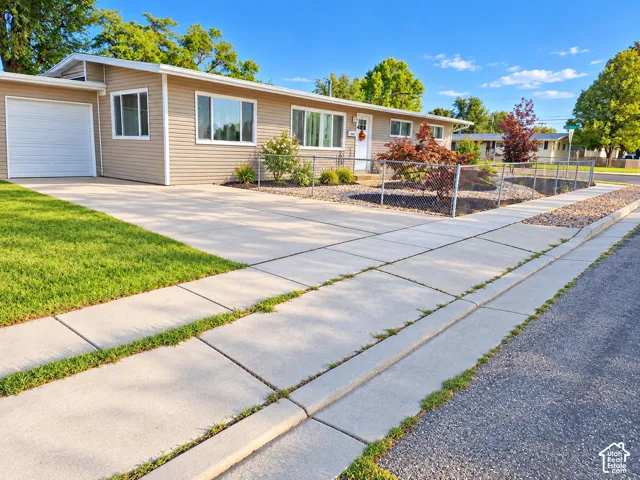 Single-story residence with horizontal siding, an attached garage, and a concrete driveway