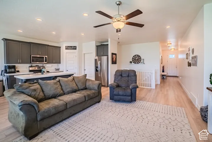 Open-concept living area featuring wood-finish flooring, recessed lighting, and a ceiling fan