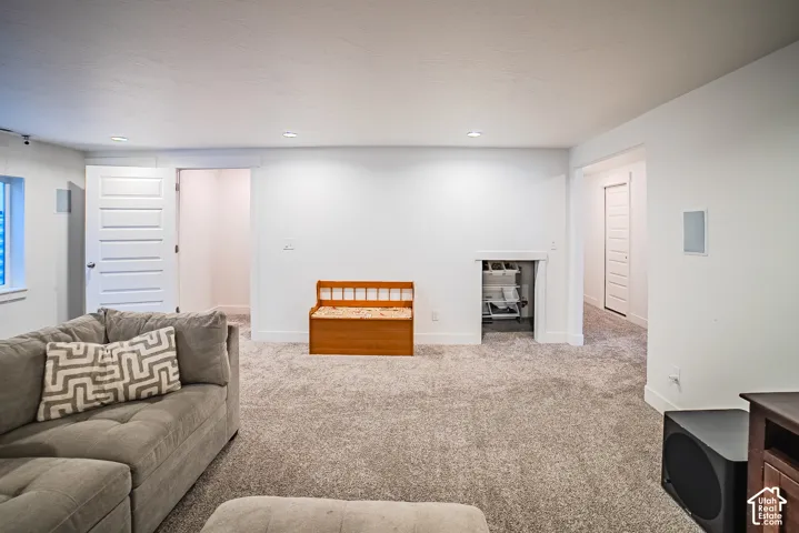 Recessed lighting, light gray carpet, white interior walls, white paneled doors, and a built-in storage alcove